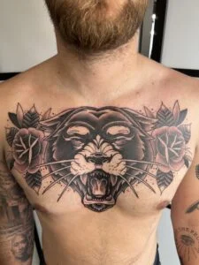 Panter tatovering på bryst med roser