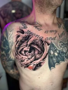 Detaljeret øjetatovering på mands bryst