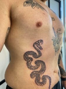 Slangetattoo på mands side og bryst