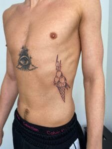 Mand med nye tatoveringer på overkrop og side