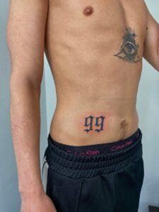 Mand med tatovering af øje og tallet 99