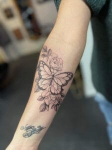 Sommerfugl og roser tatovering på underarm