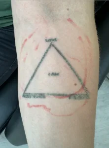 Trekantet tatovering med tekst på underarm