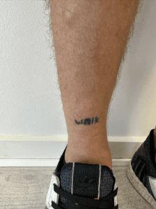 Ben med tatovering og sneakers